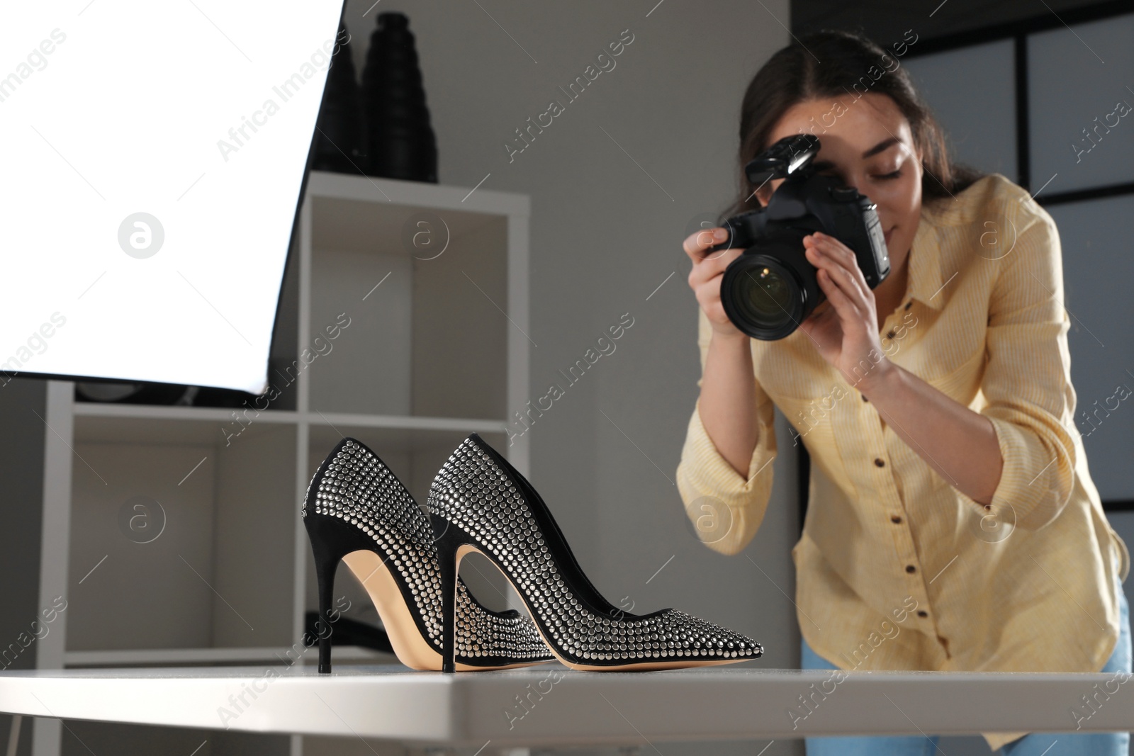 Photo of Professional photographer shooting stylish shoes in studio