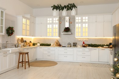 Photo of Cozy spacious kitchen decorated for Christmas. Interior design