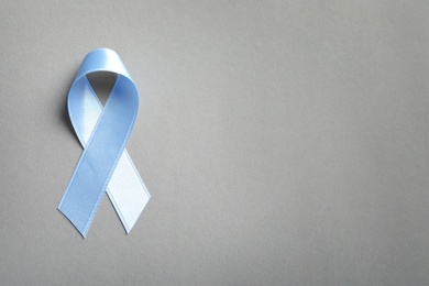 Photo of Blue ribbon on light background, top view. Cancer awareness