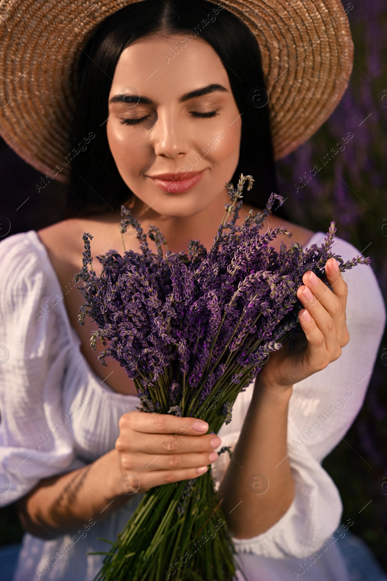 Photo of Beautiful young woman with lavender bouquet outdoors, closeup
