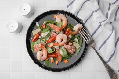 Delicious salad with pomelo, shrimps and tomatoes on white tiled table, flat lay