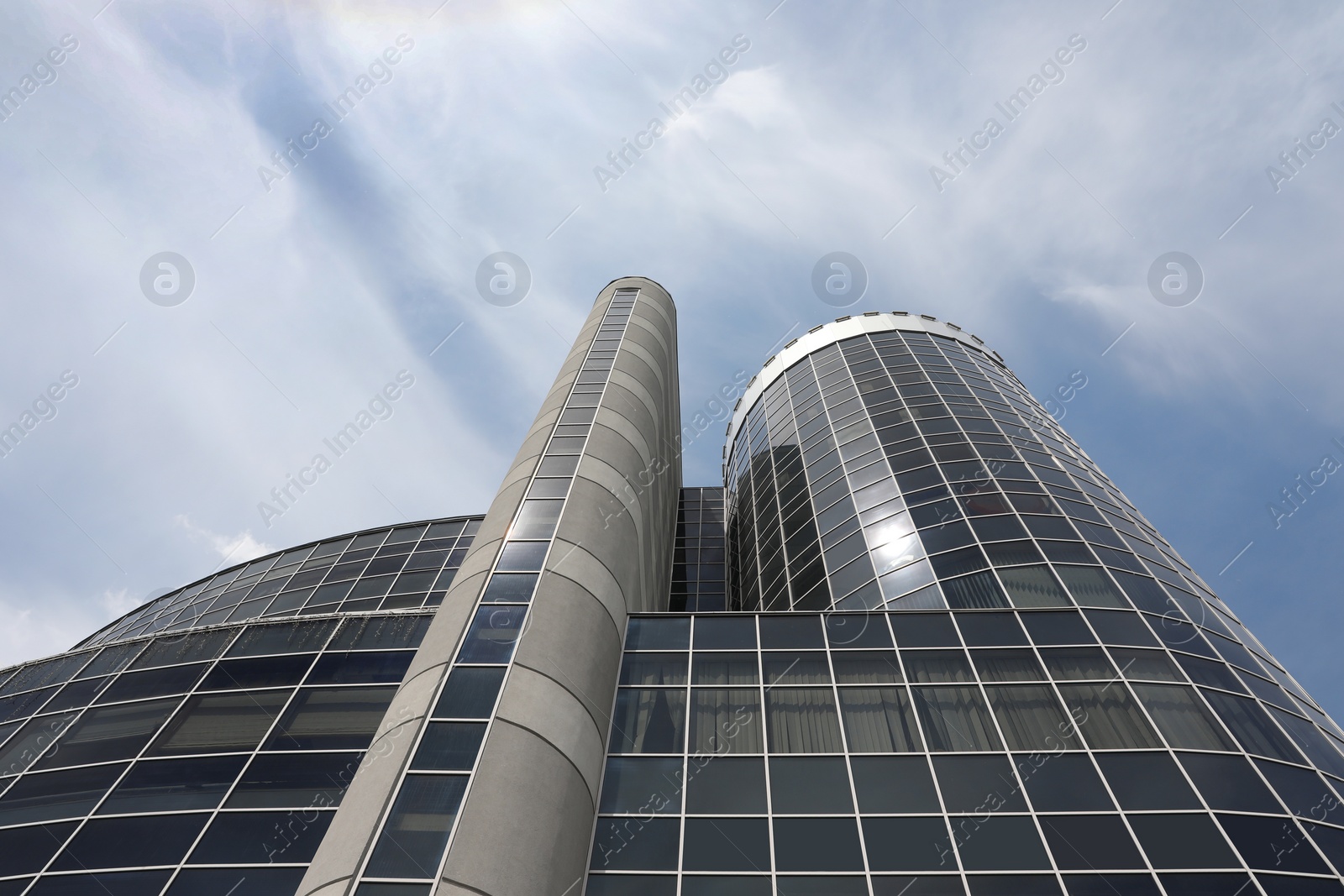 Photo of Modern building with tinted windows against sky, low angle view. Urban architecture