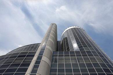 Modern building with tinted windows against sky, low angle view. Urban architecture