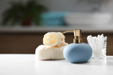 Composition with soap dispenser on white table indoors