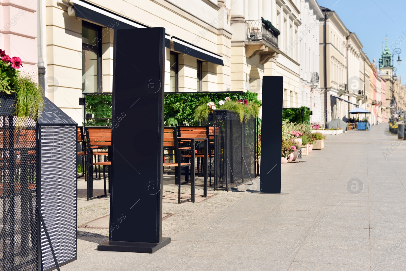 Photo of Empty chalkboard near outdoor cafe. Mockup for design