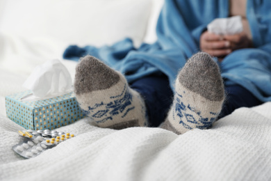 Photo of Mature man and cold remedies on bed, closeup. Dangerous virus