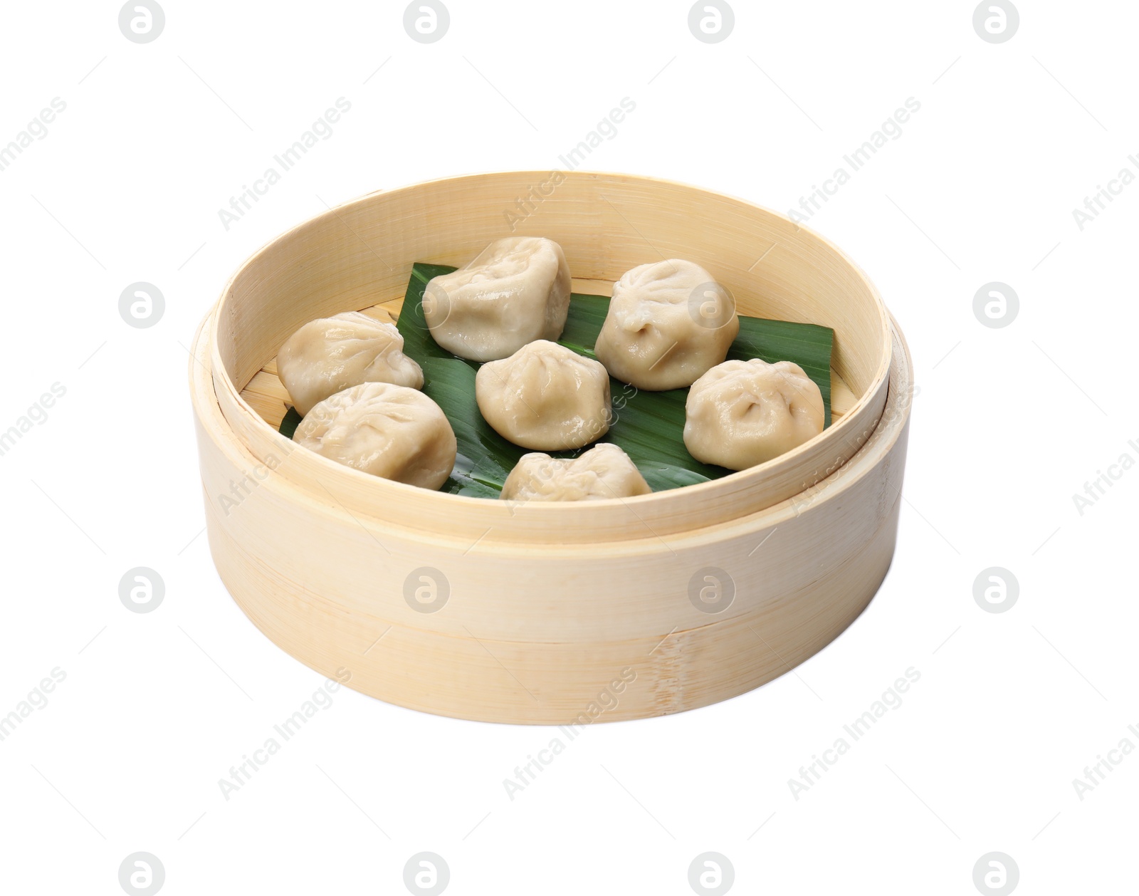 Photo of Bamboo steamer with leaves and tasty baozi dumplings on white background