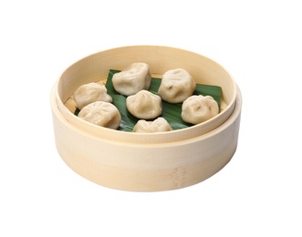 Photo of Bamboo steamer with leaves and tasty baozi dumplings on white background