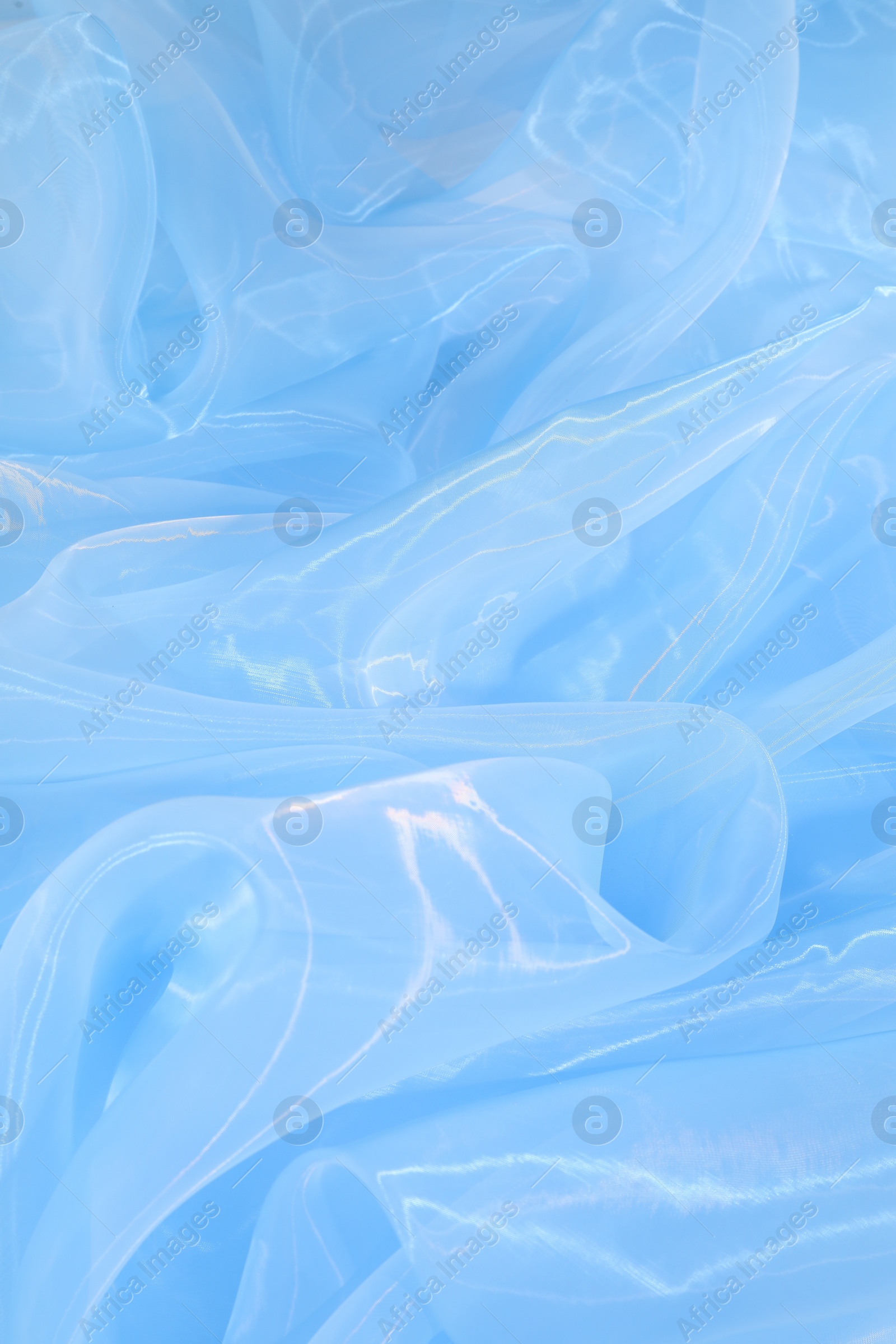 Photo of Beautiful light blue tulle fabric as background, top view