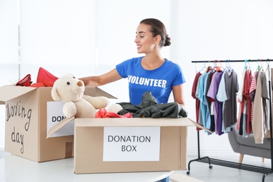 Photo of Female volunteer collecting donations at table indoors