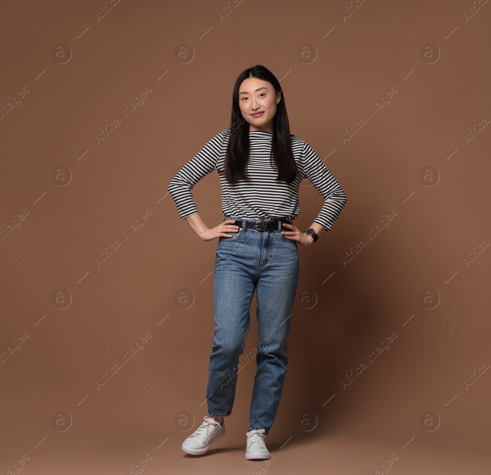 Photo of Full length portrait of beautiful woman on brown background