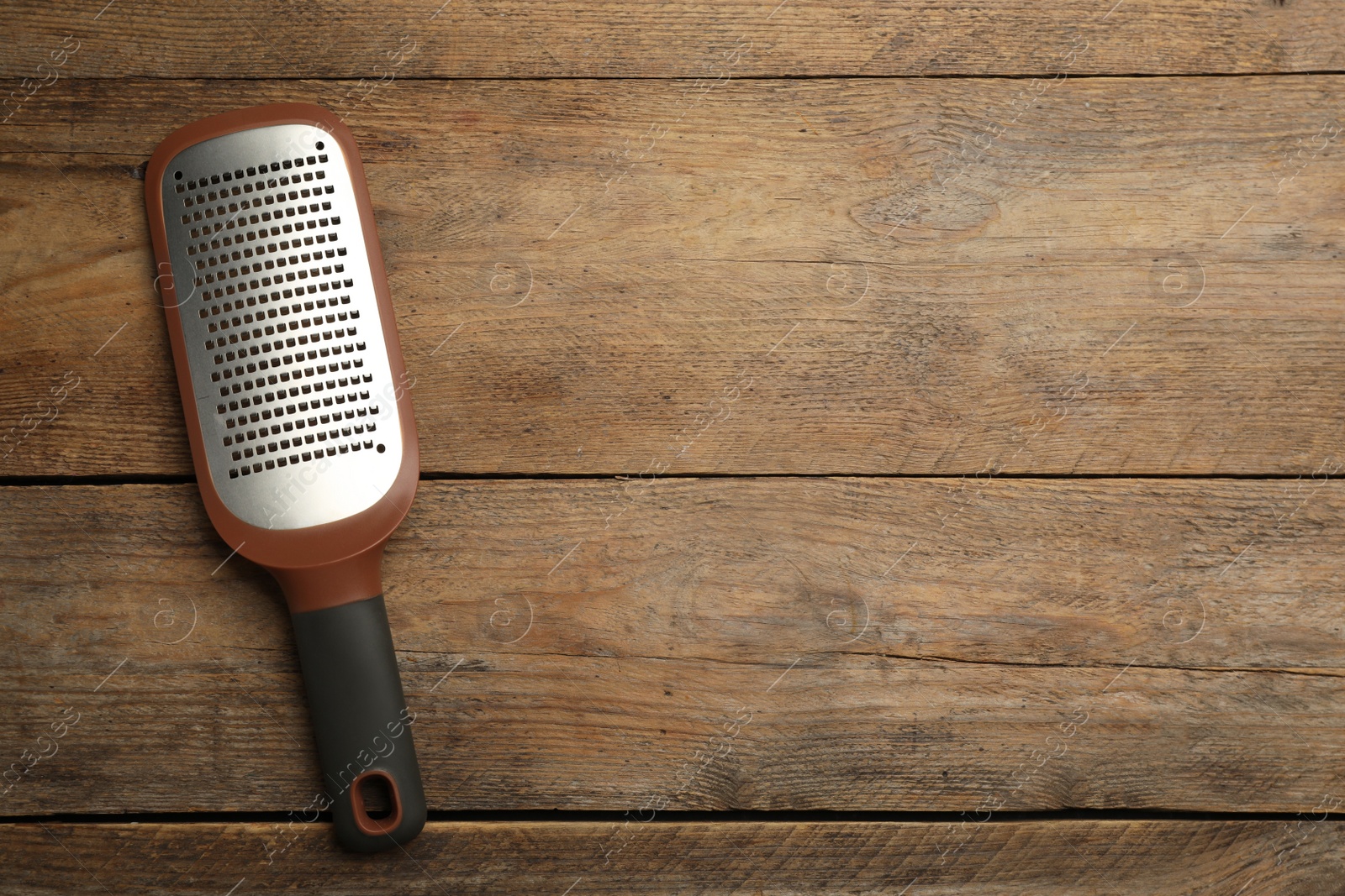 Photo of Modern grater on wooden table, top view. Space for text