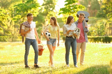 Photo of Young people with picnic basket in park on summer day