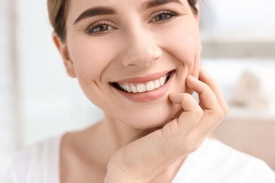 Photo of Young woman with beautiful smile indoors. Teeth whitening