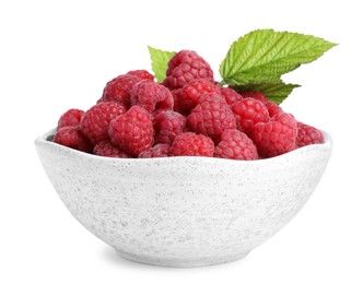 Bowl of fresh ripe raspberries with green leaves isolated on white