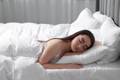 Photo of Beautiful young woman sleeping in soft bed at home