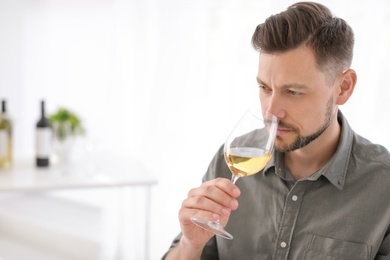 Young man with glass of wine indoors