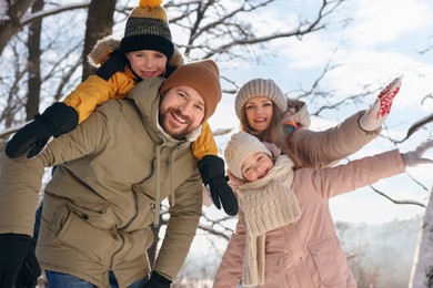 Photo of Happy family having fun in snowy forest
