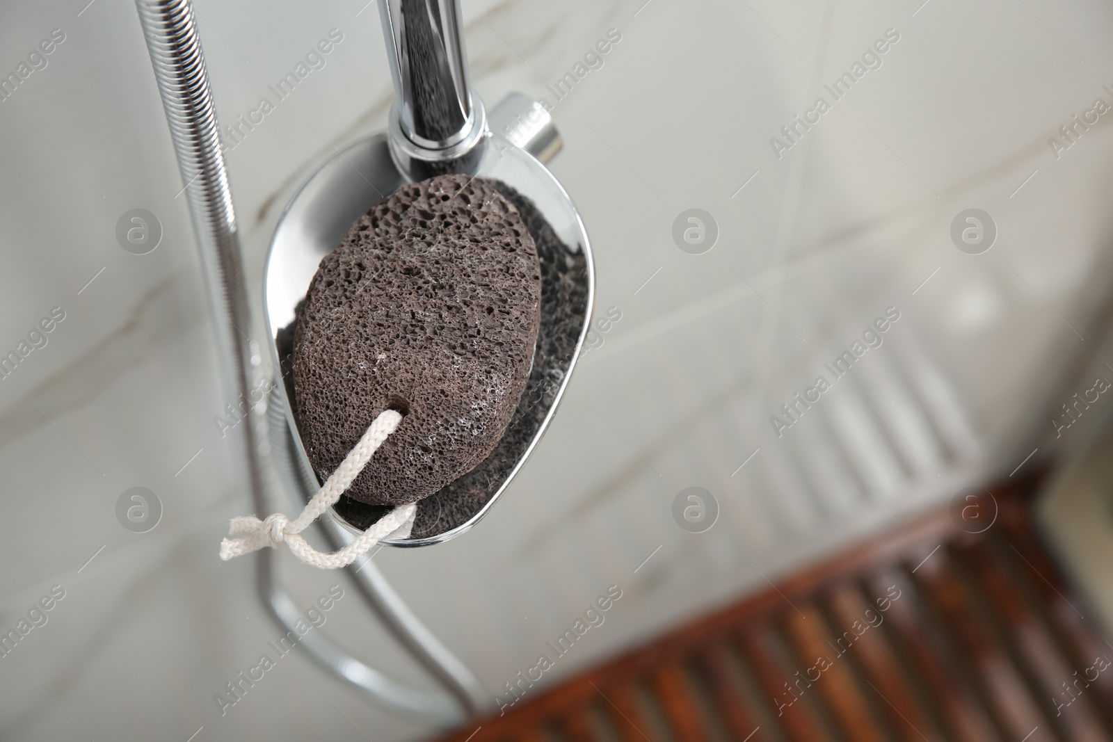 Photo of Pumice stone on metal shelf in bathroom, above view. Space for text