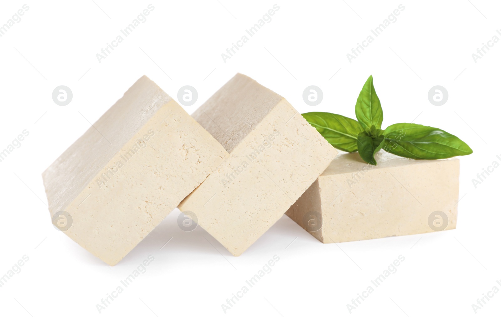 Photo of Blocks of delicious raw tofu with basil on white background