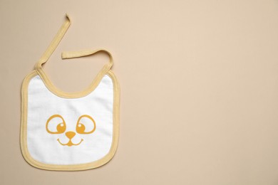 Photo of New baby bib on beige background, top view. Space for text