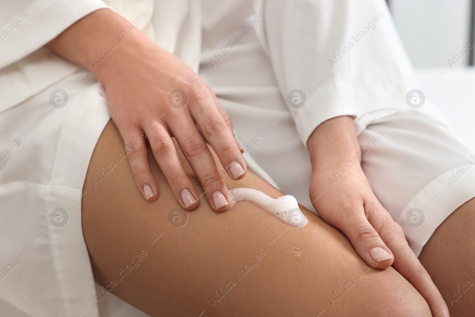 Photo of Woman applying self-tanning product onto her leg, closeup