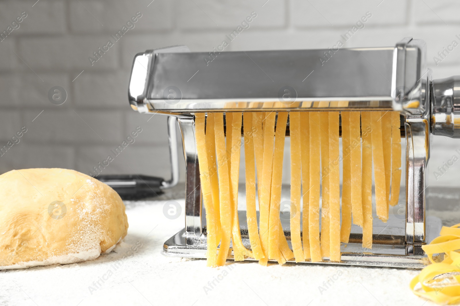 Photo of Pasta maker with dough on kitchen table