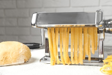 Pasta maker with dough on kitchen table