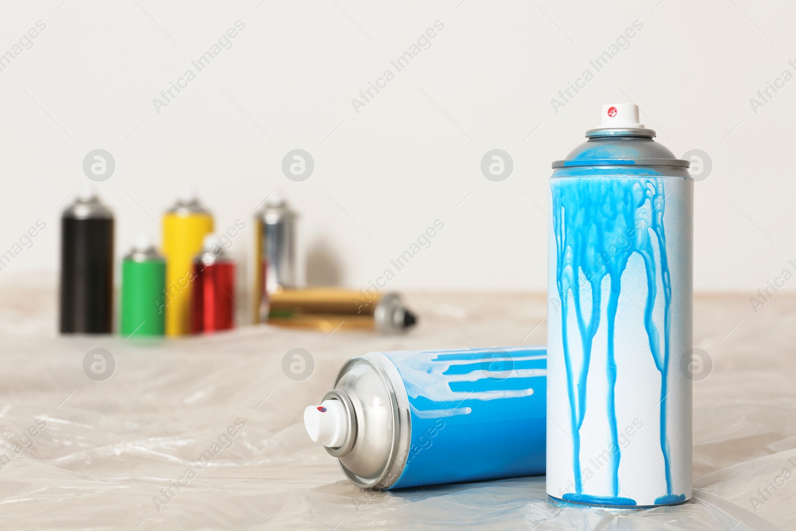 Photo of Used cans of spray paint indoors. Space for text