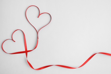 Photo of Hearts made of red ribbon on white background, top view. Valentine's day celebration