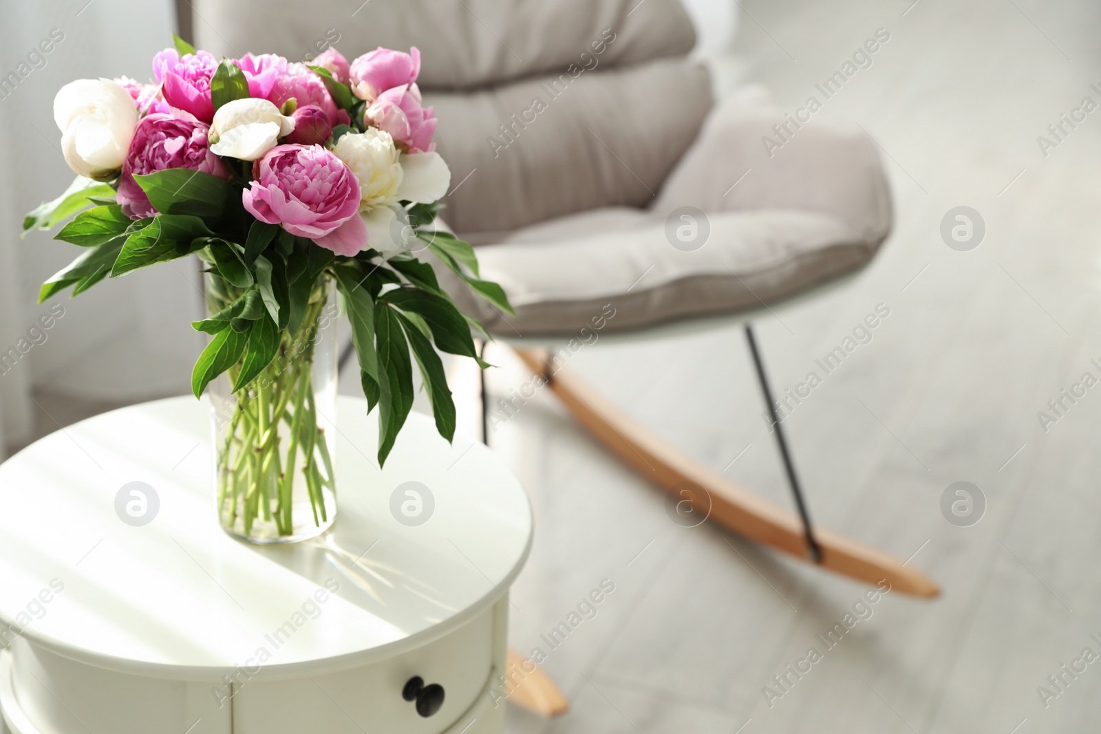 Photo of Vase with bouquet of beautiful peonies on table in room, space for text