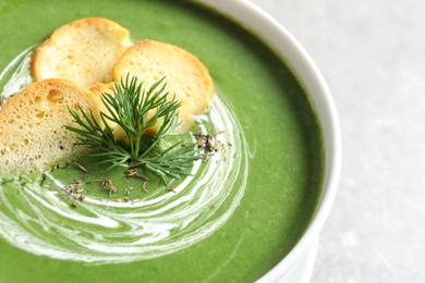 Fresh vegetable detox soup with croutons in dish on table, closeup