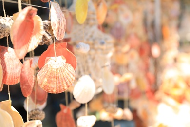 Photo of Wind chimes made of sea shells in souvenir shop, closeup. Space for text