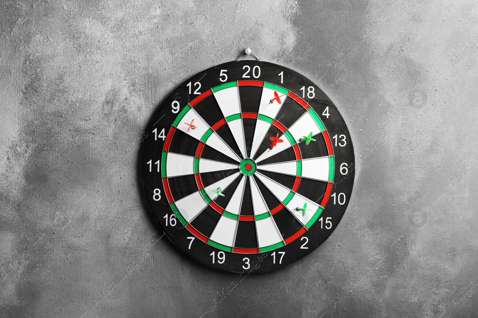 Photo of Arrows hitting dart board on grey wall