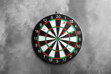 Photo of Arrows hitting dart board on grey wall