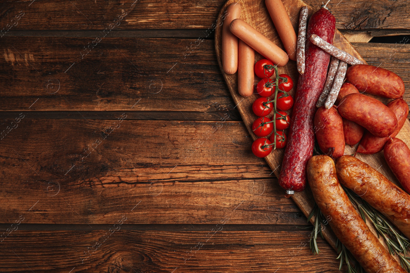 Photo of Different tasty sausages on wooden table, top view. Space for text