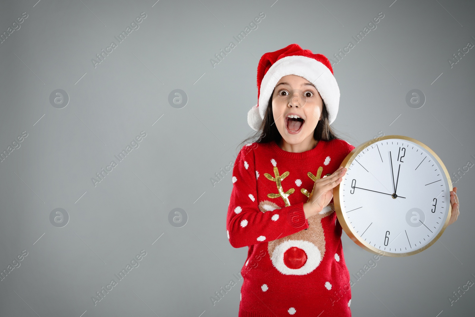 Photo of Girl in Santa hat with clock on grey background, space for text. New Year  countdown