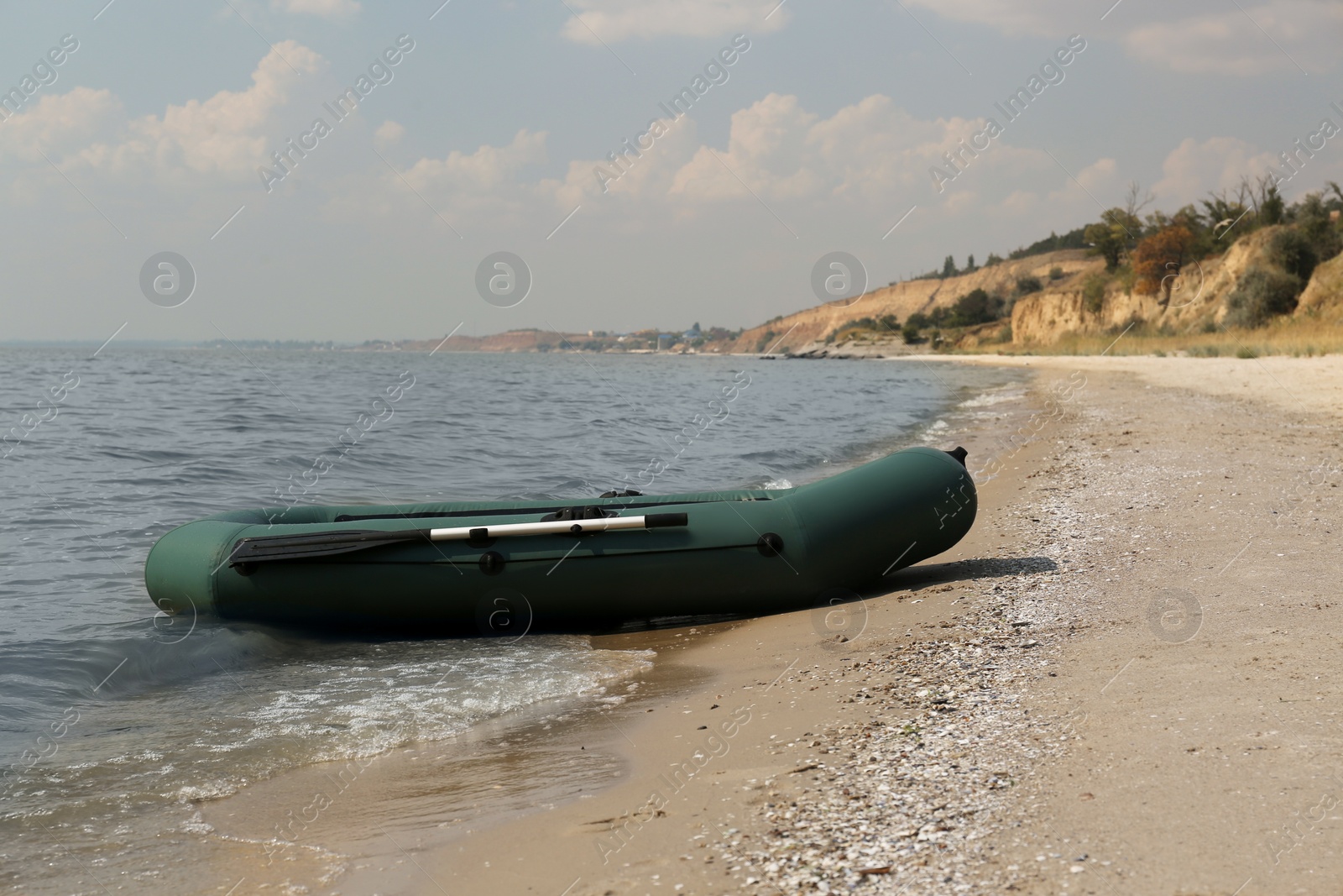 Photo of Inflatable rubber fishing boat on sandy beach near sea