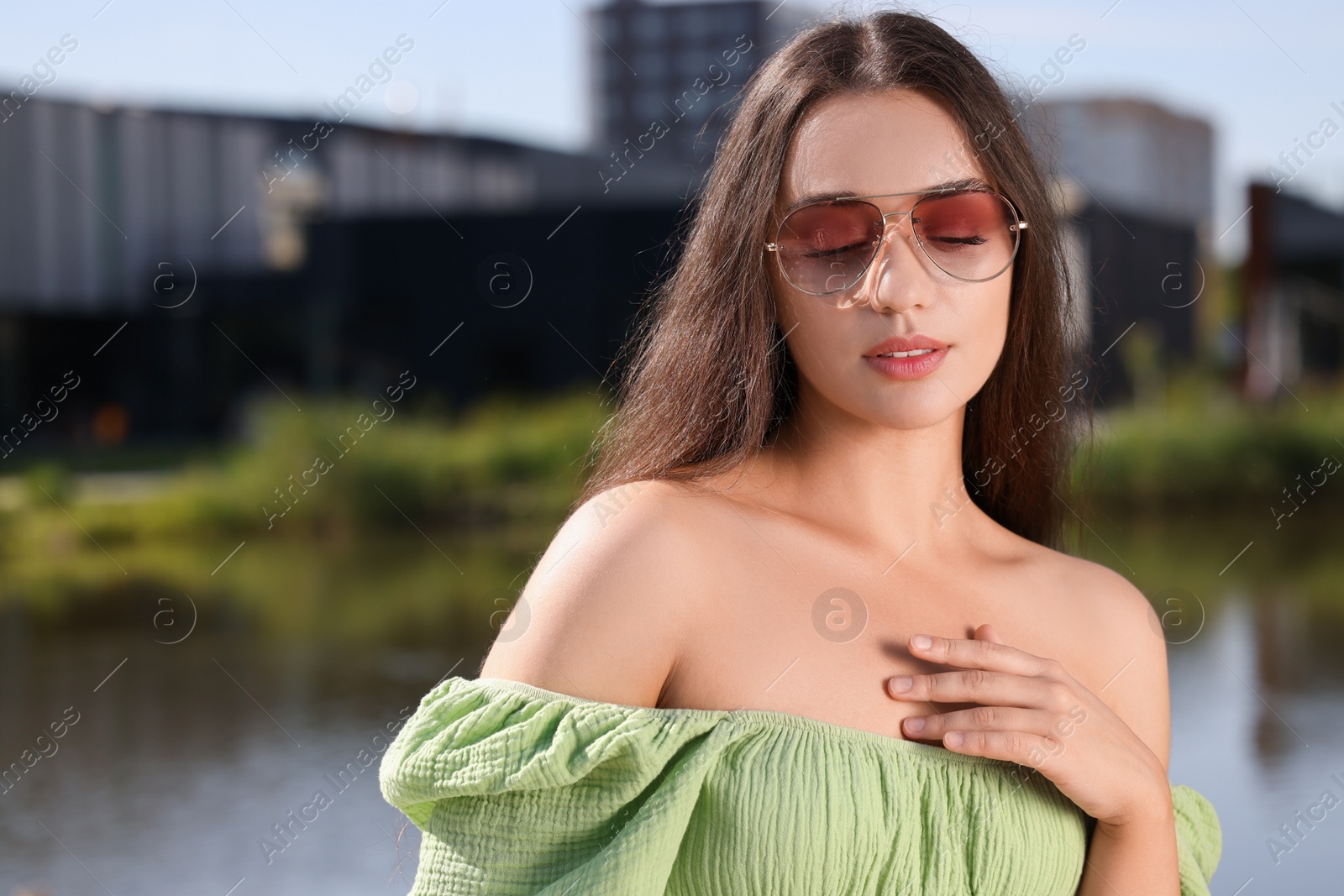 Photo of Beautiful woman in sunglasses near river, space for text