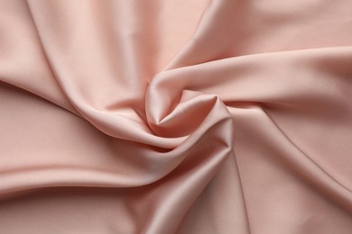 Photo of Crumpled pink silk fabric as background, top view