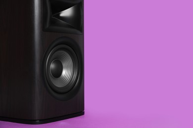 Photo of One wooden sound speaker on violet background, closeup. Space for text