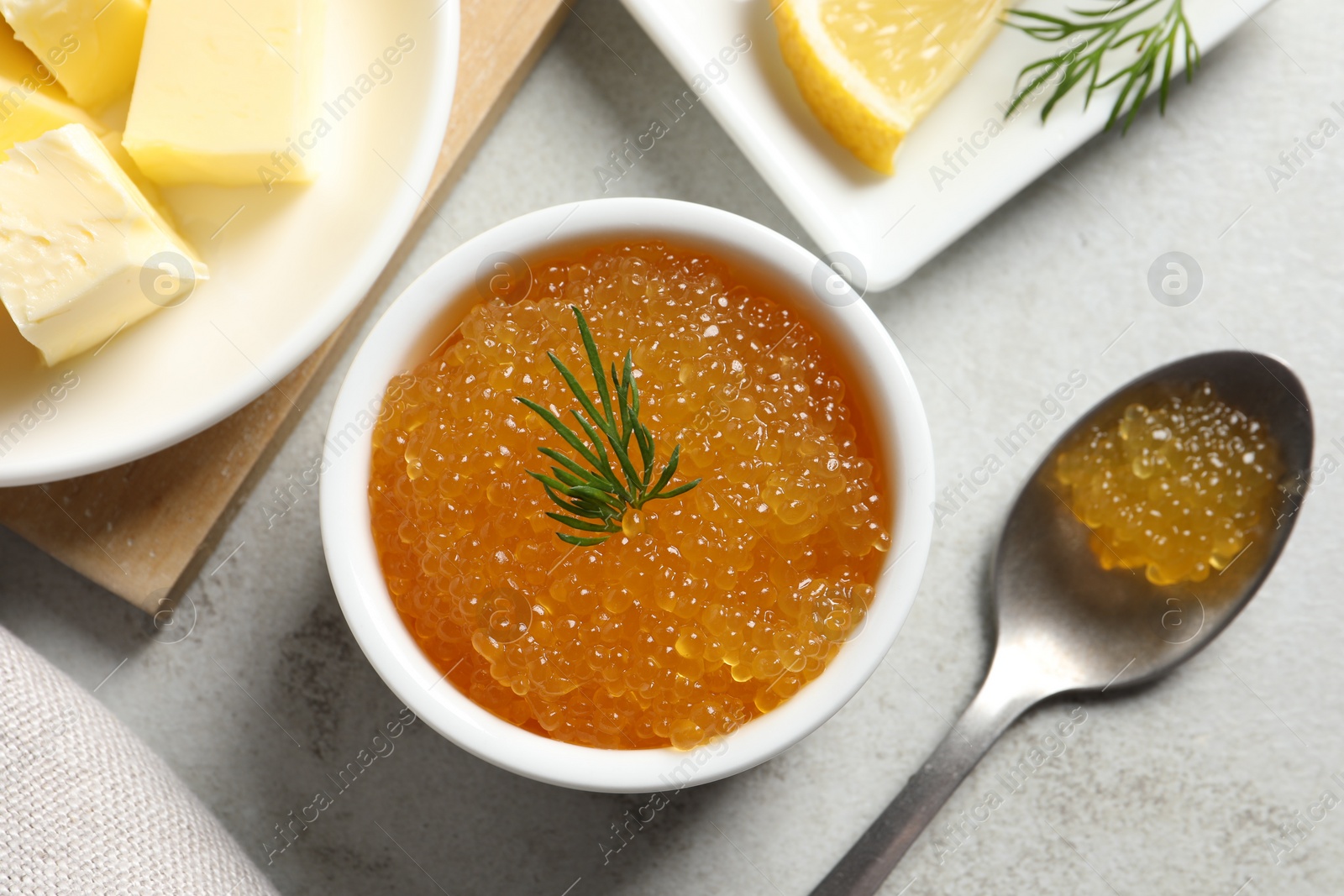 Photo of Fresh pike caviar, dill, butter and lemon on light grey table, top view