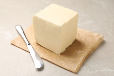 Photo of Block of tasty butter and knife on light table