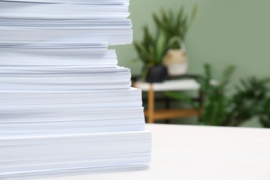 Stack of paper sheets on white table indoors, closeup. Space for text