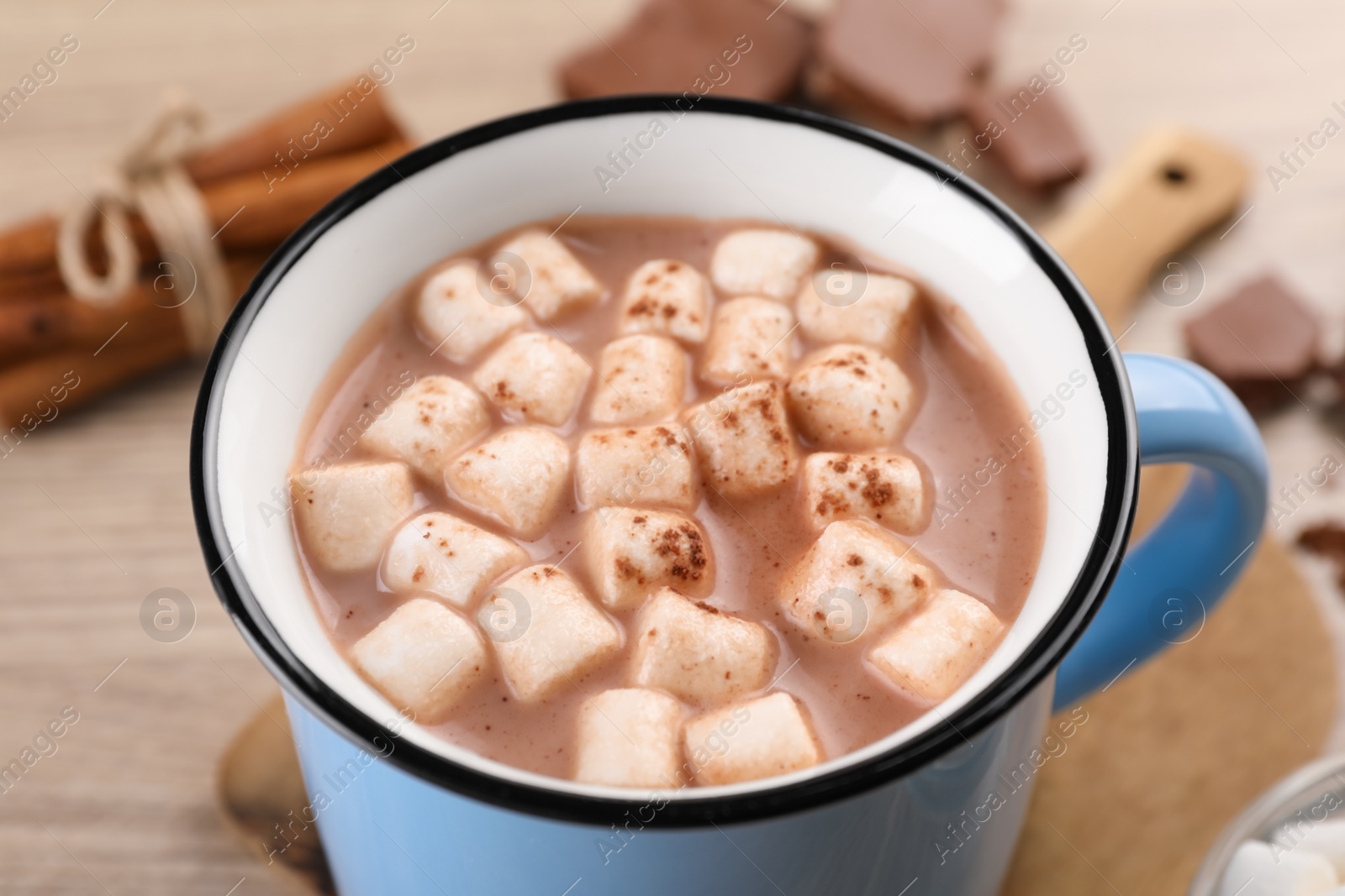 Photo of Cup of aromatic hot chocolate with marshmallows and cocoa powder on table, closeup