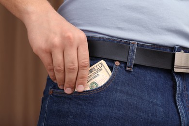 Photo of Man putting money into pocket of jeans, closeup