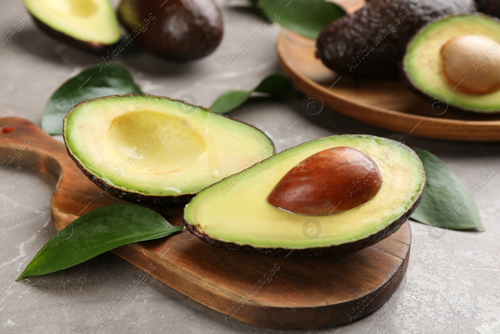 Photo of Fresh cut avocado on grey marble table, closeup