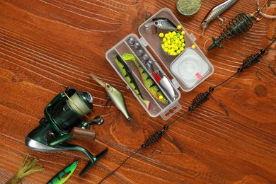 Photo of Fishing tackle on wooden table, flat lay