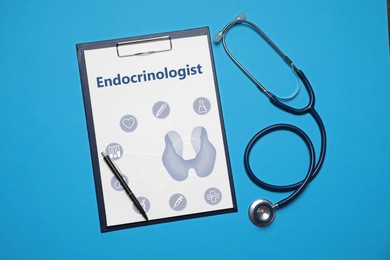 Image of Paper with word Endocrinologist, thyroid illustration and icons. Clipboard, stethoscope and pen on light blue background, flat lay