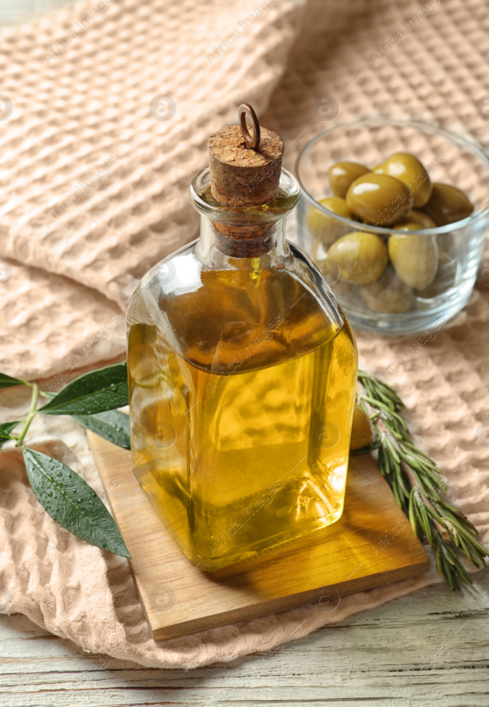 Photo of Bottle with fresh olive oil on table